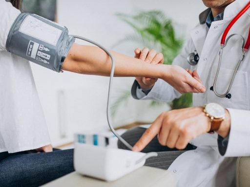 Arts meet de bloeddruk van een patiënt tijdens een preventief gezondheidsonderzoek