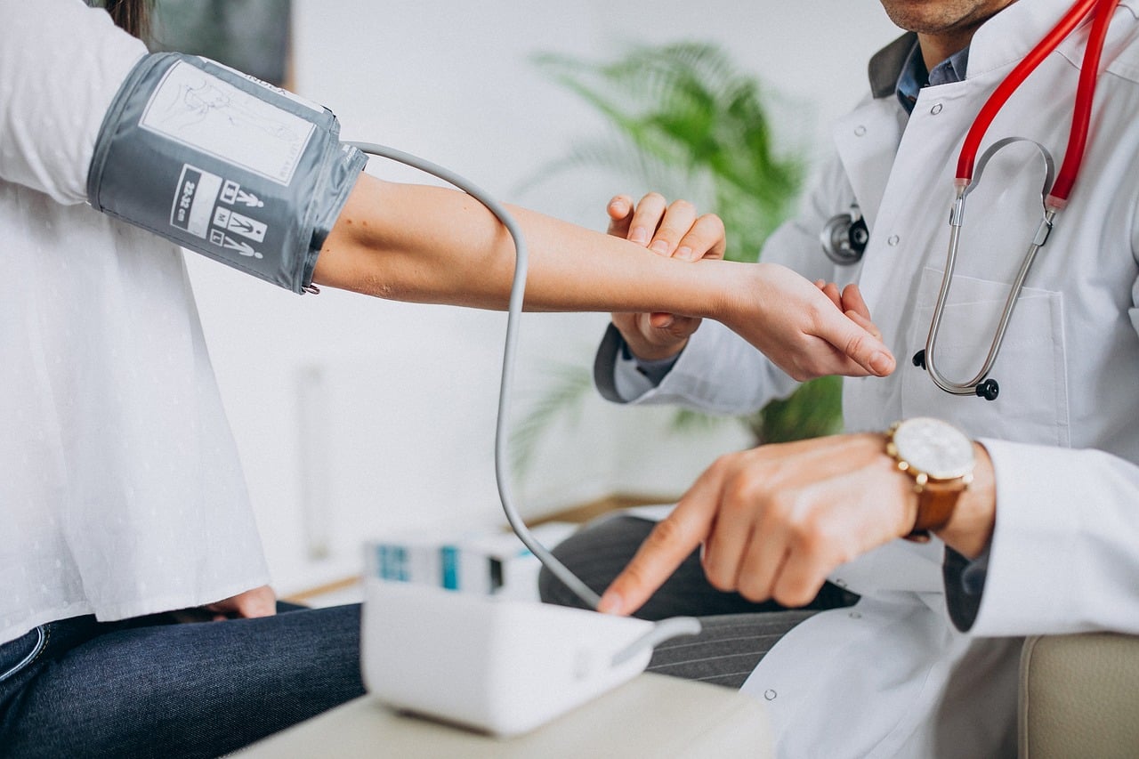 Arts meet de bloeddruk van een patiënt tijdens een preventief gezondheidsonderzoek