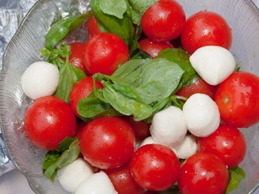 Kleurrijke zomerse salade met tomaat, komkommer en kruiden in een kom