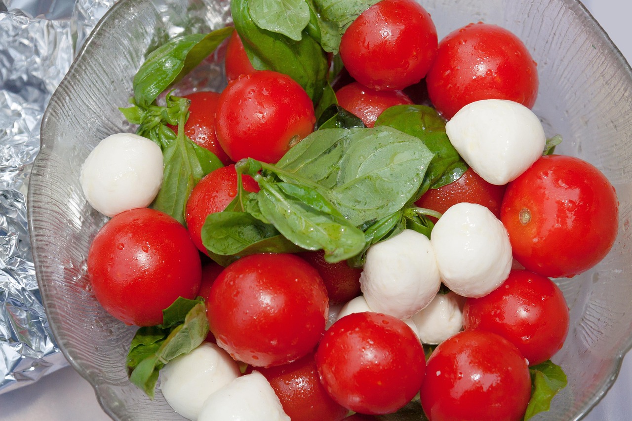 Kleurrijke zomerse salade met tomaat, komkommer en kruiden in een kom