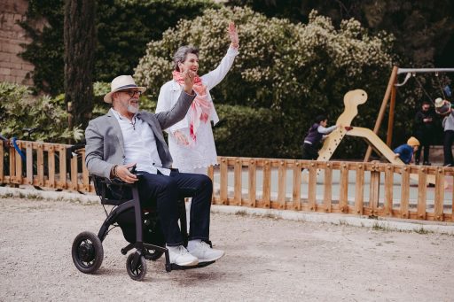 Oudere vrouw die buiten loopt met een vierwielige rollator op een stoep