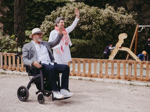 Oudere vrouw die buiten loopt met een vierwielige rollator op een stoep