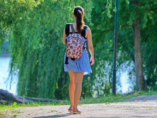 Vrouw wandelt op een zonnige zomerdag door een groen park