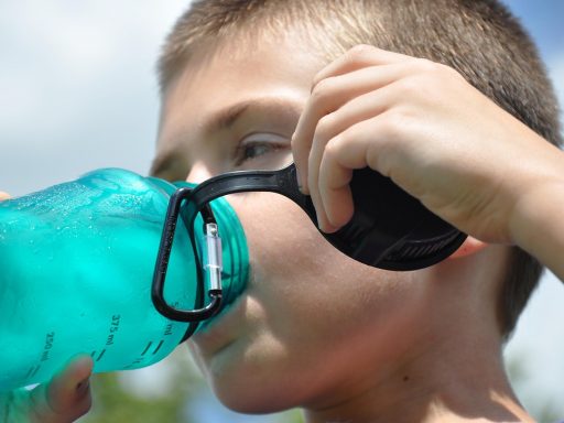 Persoon die water drinkt buiten in de zomerhitte