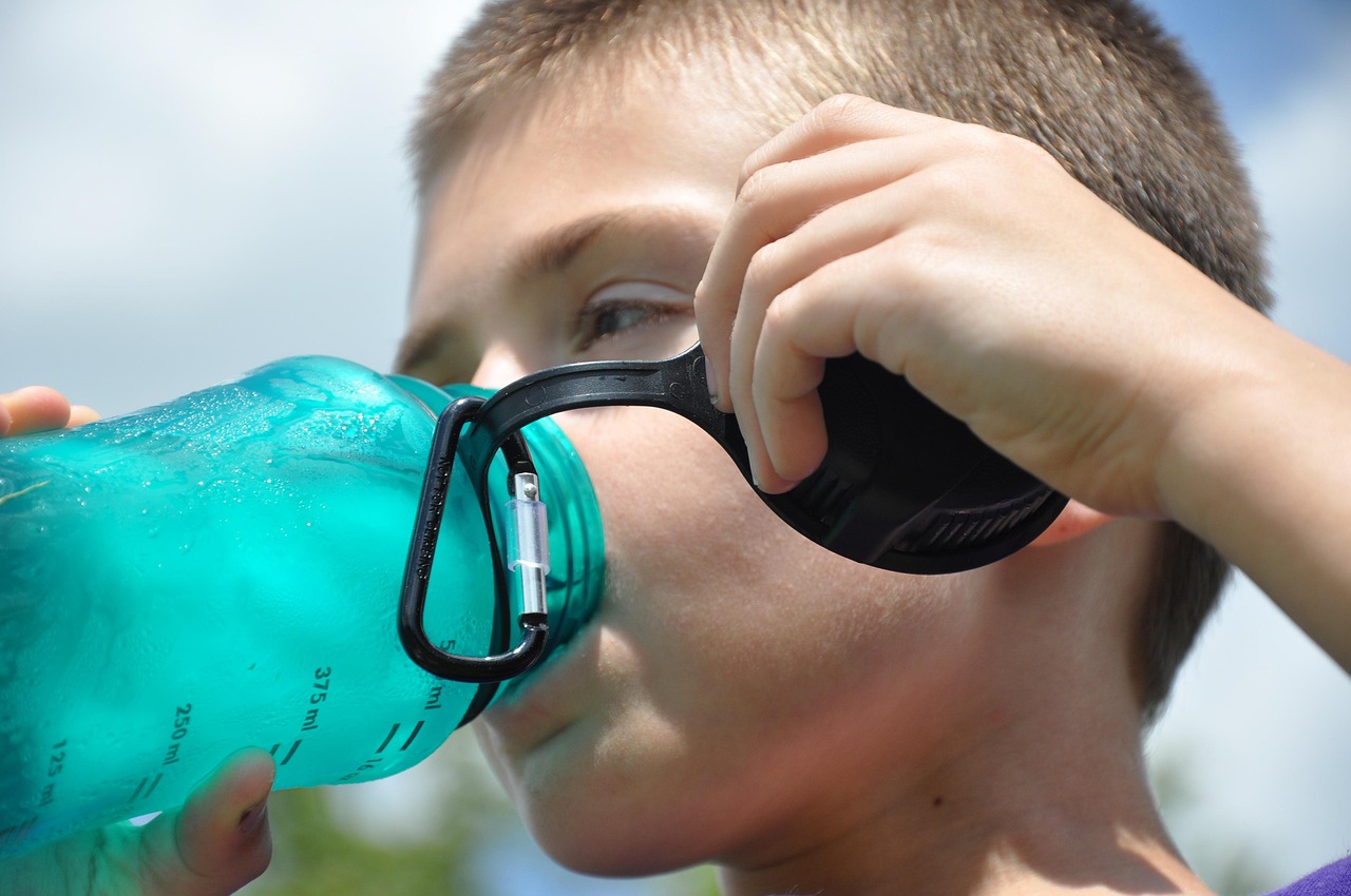 Persoon die water drinkt buiten in de zomerhitte