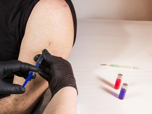 Een verpleegkundige geeft een vaccinatie in de bovenarm van een volwassene