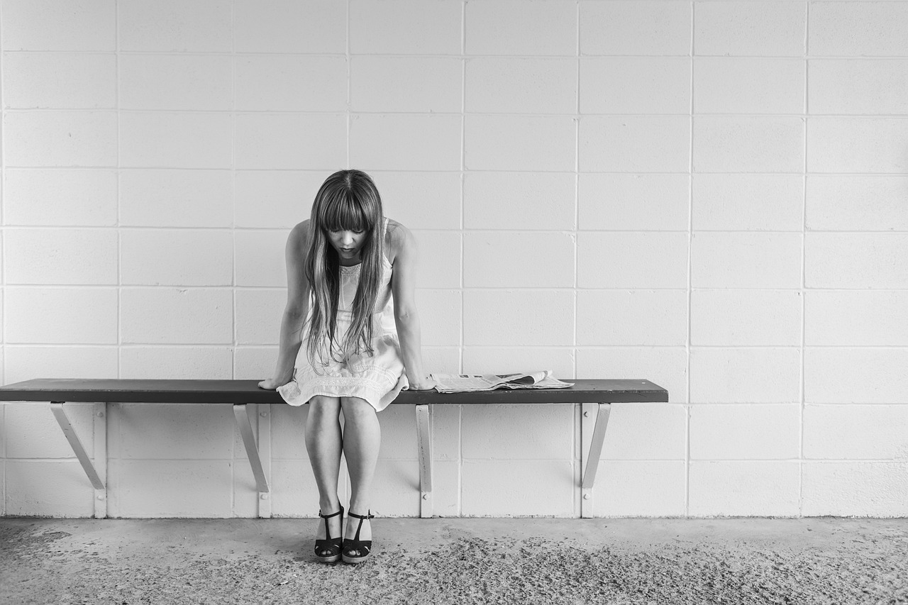 Persoon die peinzend zit en nadenkt over zorgen en piekergedachten