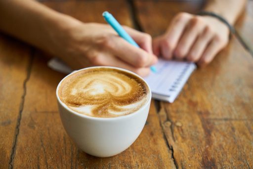Persoon die 's ochtends buiten wandelt met een koffiebeker in de hand
