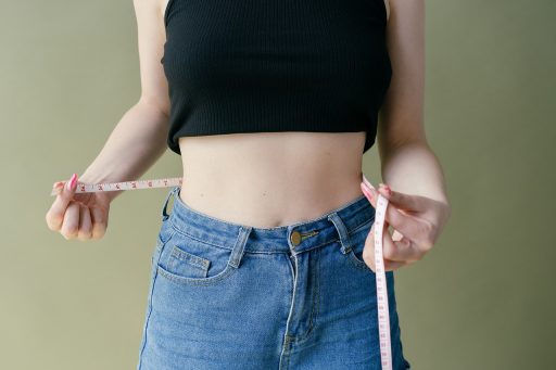 Persoon die de middelomtrek opmeet met een meetlint als aanvulling op BMI