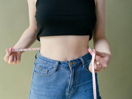 Persoon die de middelomtrek opmeet met een meetlint als aanvulling op BMI