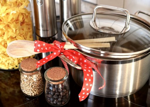 Kleine keuken met twee pannen op het fornuis en stapelbare bakjes met bereide maaltijden op het aanrecht
