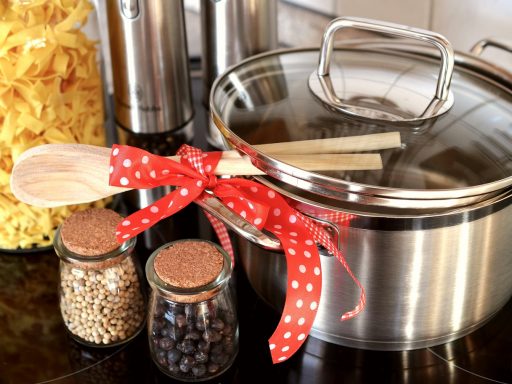 Kleine keuken met twee pannen op het fornuis en stapelbare bakjes met bereide maaltijden op het aanrecht