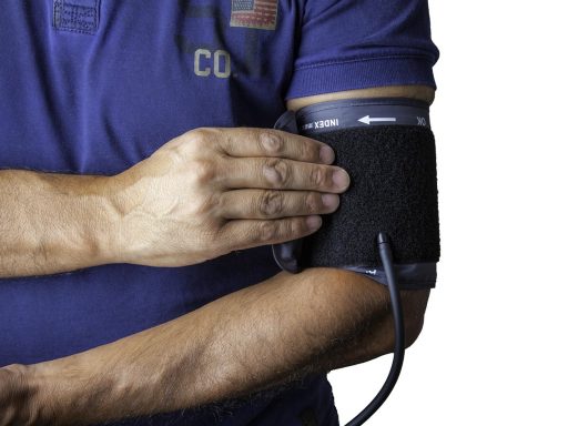 Preventieassistente meet de bloeddruk van een patiënt tijdens een consult in de huisartsenpraktijk