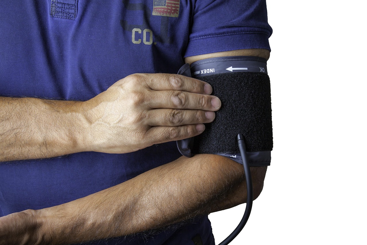 Preventieassistente meet de bloeddruk van een patiënt tijdens een consult in de huisartsenpraktijk