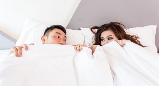 Persoon slaapt in een donkere slaapkamer met gordijnen dicht