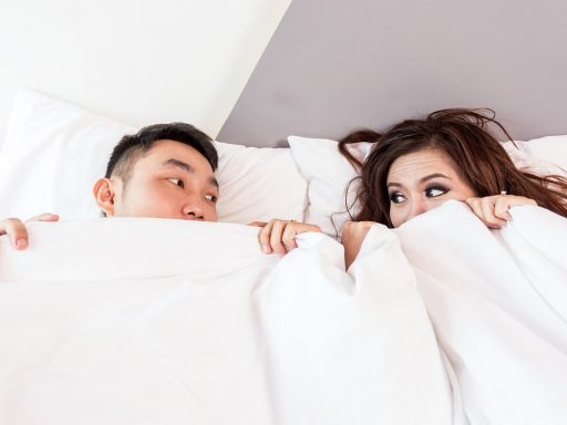 Persoon slaapt in een donkere slaapkamer met gordijnen dicht