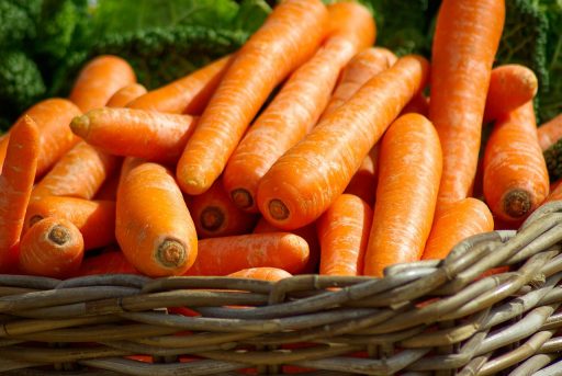 Een tafel met vezelrijke voeding zoals havermout, peulvruchten, volkorenbrood, noten en verse groenten
