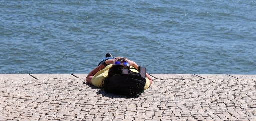 Persoon die in de zomerse tuin van de zon geniet met blote armen en benen
