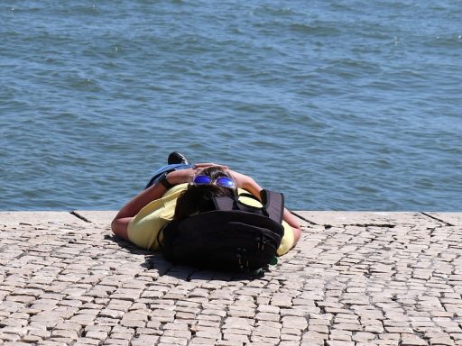 Persoon die in de zomerse tuin van de zon geniet met blote armen en benen