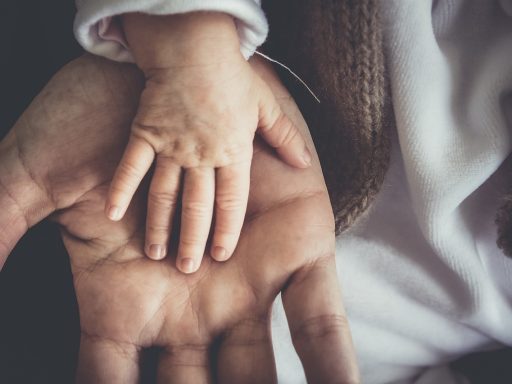 Ouder meet de temperatuur van een ziek kind in bed