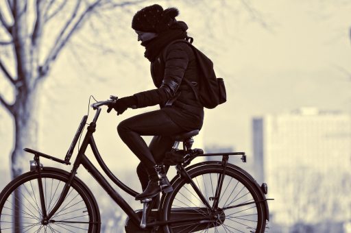 Een volwassene fietst stevig buiten op een zonnige dag als voorbeeld van matig intensieve beweging