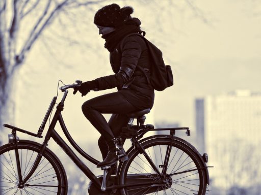 Een volwassene fietst stevig buiten op een zonnige dag als voorbeeld van matig intensieve beweging