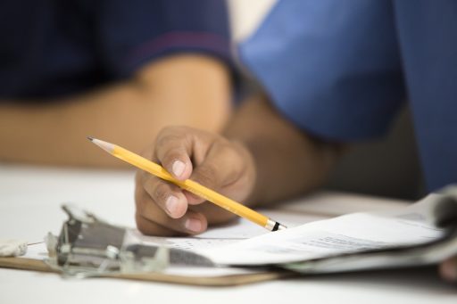 Persoon die zorgverzekeringsdocumenten en nota's controleert aan een bureau