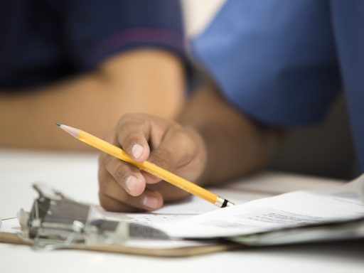 Persoon die zorgverzekeringsdocumenten en nota's controleert aan een bureau