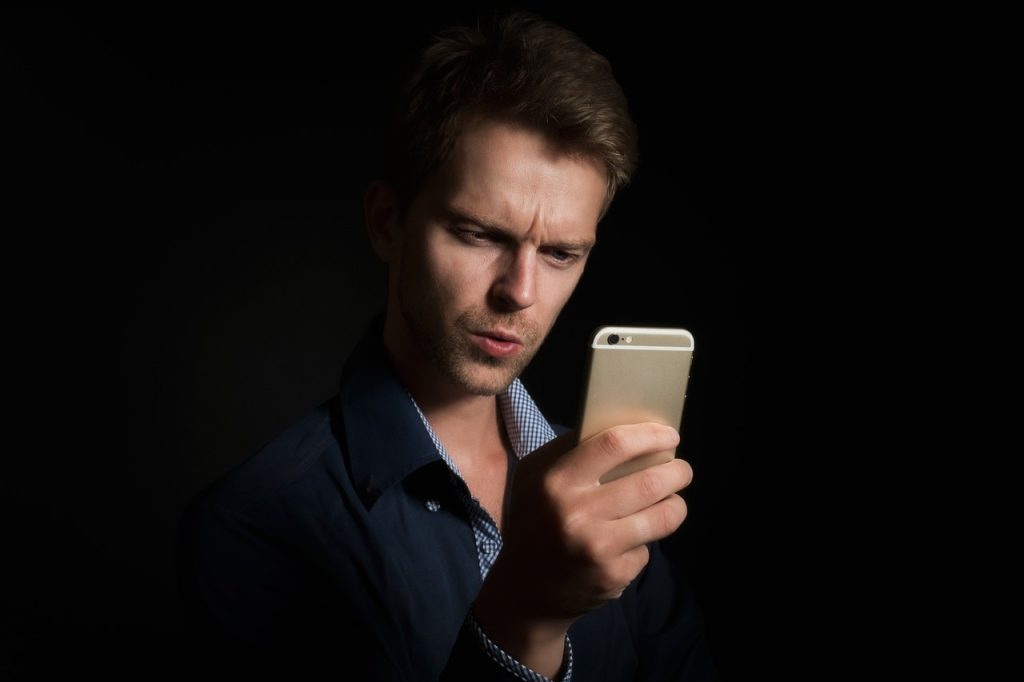 Persoon die ontspannen op een bank een mentale gezondheid app gebruikt op zijn smartphone