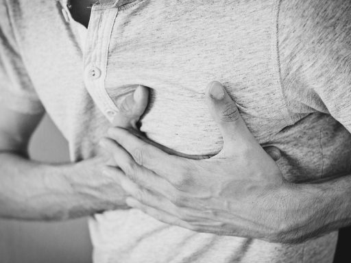 Een persoon die met beide handen de voet vasthoudt, symbolisch voor tintelingen in handen en voeten door perifere neuropathie