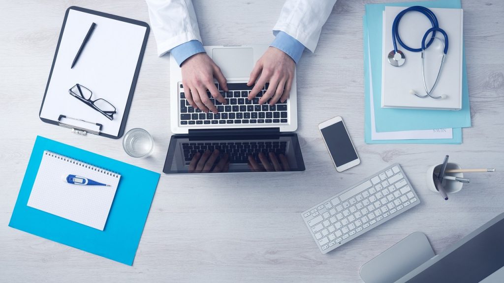 Huisarts bekijkt diagnostische informatie op een computerscherm tijdens een consult
