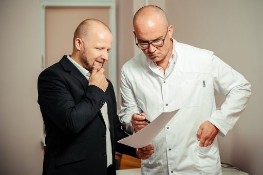 Bedrijfsarts in gesprek met werknemer tijdens consult op kantoor
