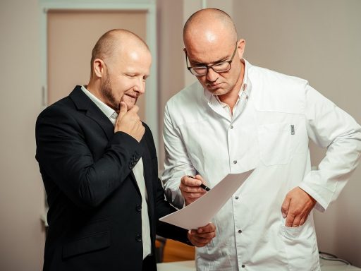 Bedrijfsarts in gesprek met werknemer tijdens consult op kantoor