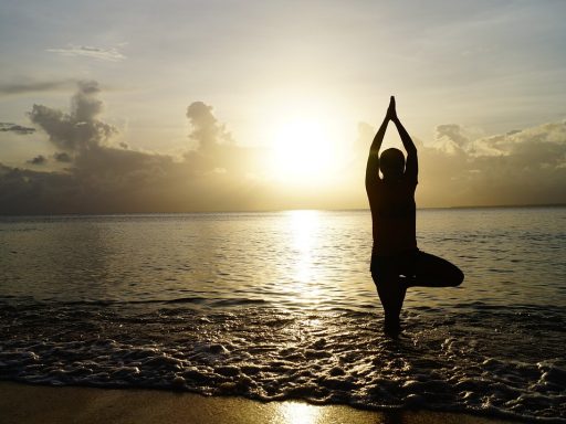 Vrouw doet rustige yoga-oefeningen binnen op een herfstdag met zicht op de tuin