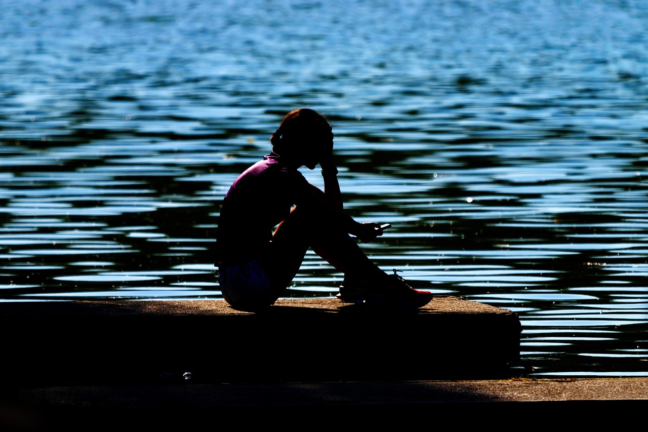Uitgeputte persoon achter bureau die hoofd in handen heeft, als beeld bij burn-out en arbeidsongeschiktheid