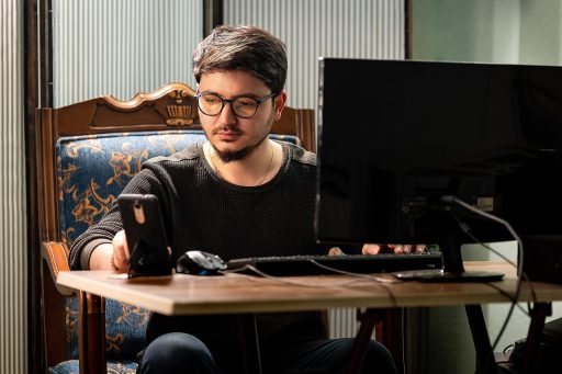 Persoon die op een laptop een online therapiesessie volgt aan een bureau thuis