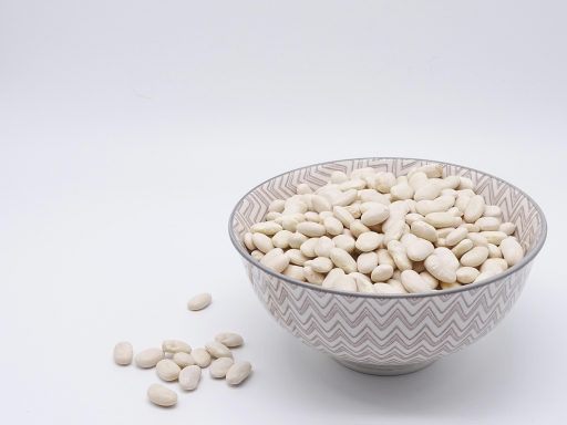 Een verscheidenheid aan plantaardige eiwitrijke voedingsmiddelen zoals edamame, linzen, tofu en noten in kommen op een tafel
