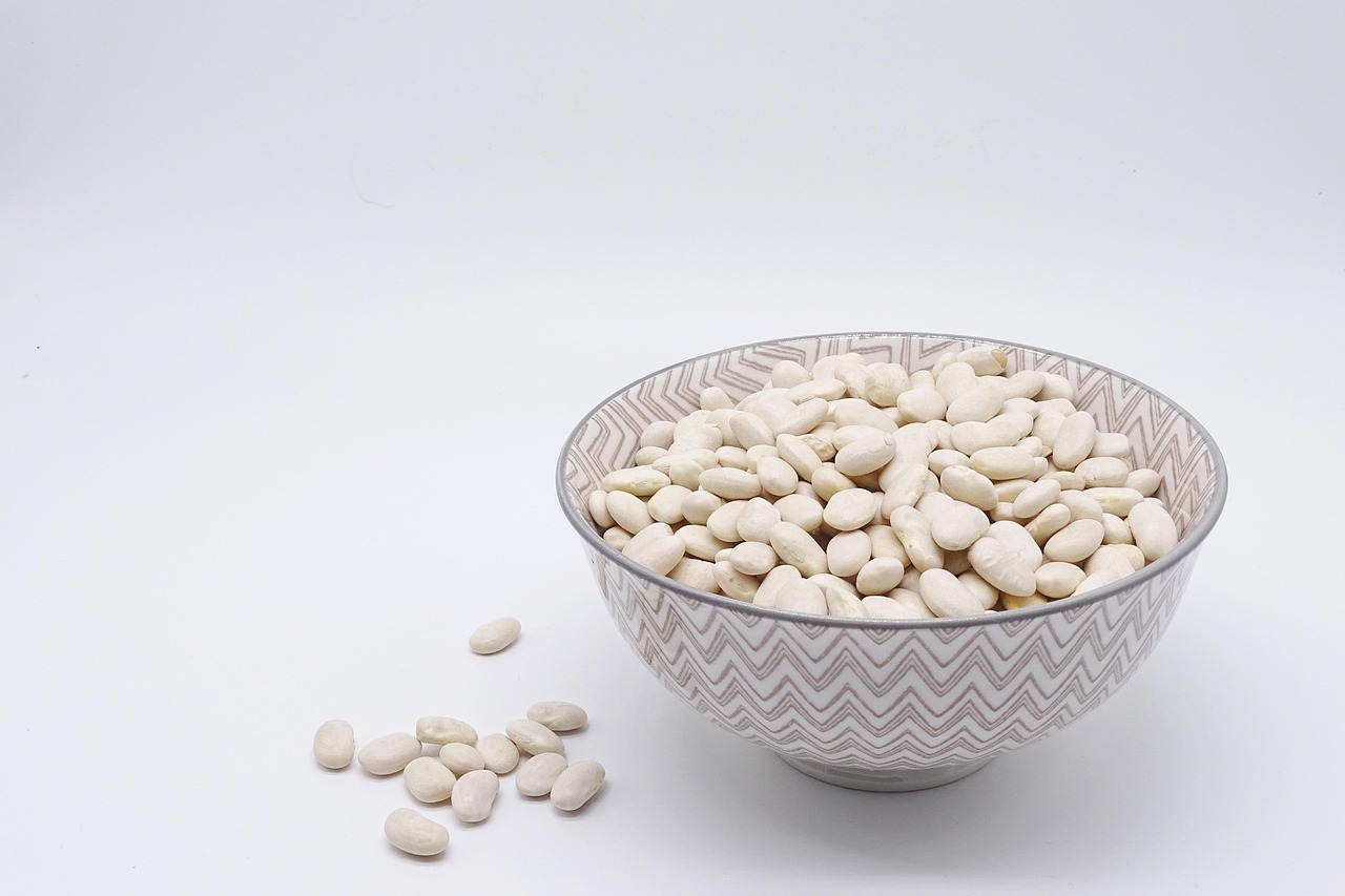 Een verscheidenheid aan plantaardige eiwitrijke voedingsmiddelen zoals edamame, linzen, tofu en noten in kommen op een tafel
