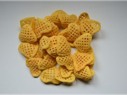 Een jong kind dat crackers eet aan een keukentafel