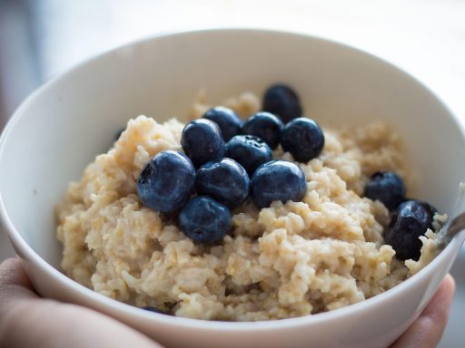 Een kom havermout met vers fruit en lijnzaad als gezond ontbijt bij een hoog cholesterol