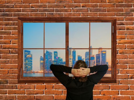 Persoon die even rust neemt bij een kantoorveinster tijdens een drukke werkdag