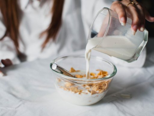 Vrouw eet een gezond tussendoortje van noten en fruit
